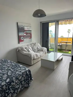 a living room with a couch and a glass table at Appartement vue mer CALIFORNIE PROMENADE DES ANGLAIS in Nice