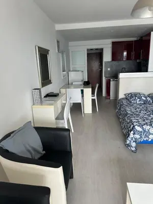 a room with a bed and a table and a bedroom at Appartement vue mer CALIFORNIE PROMENADE DES ANGLAIS in Nice