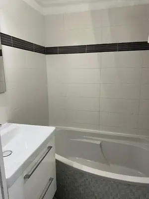 a white bathroom with a tub and a sink at Appartement vue mer CALIFORNIE PROMENADE DES ANGLAIS in Nice