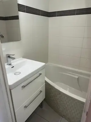 a white bathroom with a sink and a bath tub at Appartement vue mer CALIFORNIE PROMENADE DES ANGLAIS in Nice