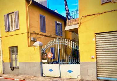 a yellow building with a gate on the side of it at 3 pièces près du Port de Nice in Nice