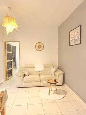 a living room with a couch and a table at 3 pièces près du Port de Nice in Nice