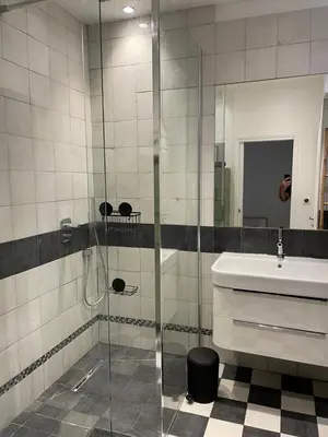 a bathroom with a glass shower and a sink at Palais Libération 3 pièces in Nice