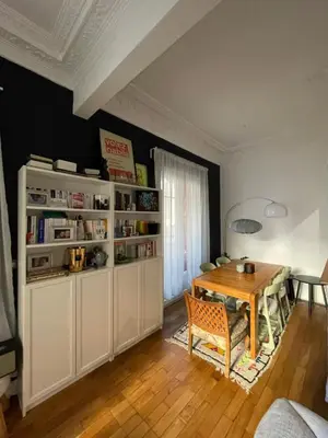 a dining room with a table and a book shelf at Palais Libération 3 pièces in Nice
