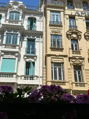 a building with windows and purple flowers in front of it at Gaya in Nice