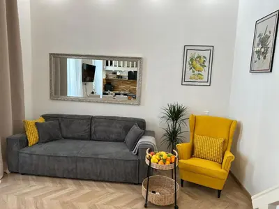 a living room with a gray couch and a yellow chair at Gaya in Nice