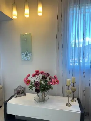 a vase of flowers on a table with candles at Maison Ariana in Nice
