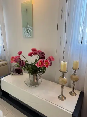 a table with a vase of flowers and candles on it at Maison Ariana in Nice