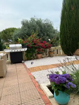 a backyard with a barbecue grill and some flowers at Magnifique studio entier avec terrasse Saint Jean Cap Ferrat in Saint-Jean-Cap-Ferrat
