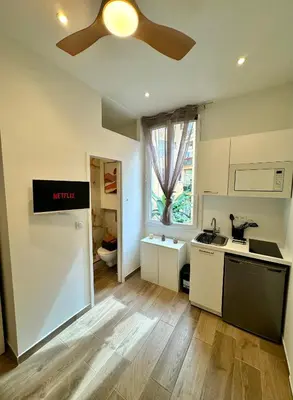 a kitchen with a ceiling fan and a counter top at Cosy studio le port in Nice