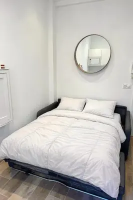 a bedroom with a bed with a mirror on the wall at Cosy studio le port in Nice