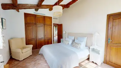 a bedroom with a white bed and a chair at Villa Ezea - vue mer et charme in Èze