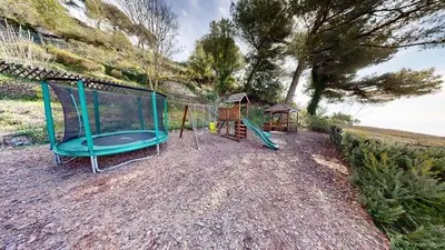 a playground with two swings and a gazebo at Villa Ezea - vue mer et charme in Èze