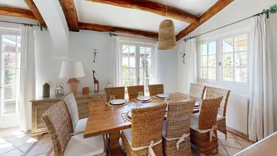 a dining room with a wooden table and chairs at Villa Ezea - vue mer et charme in Èze