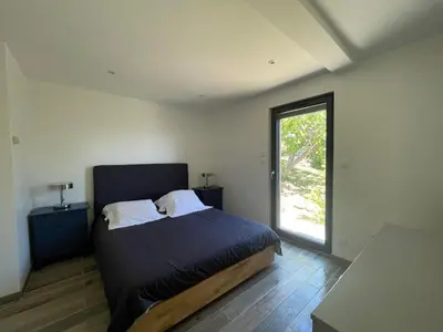 a bedroom with a bed and a large window at La Petite Maison des Baous in Saint-Jeannet