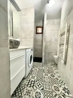 a bathroom with a washer and dryer on a tile floor at La Petite Maison des Baous in Saint-Jeannet