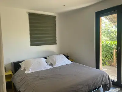 a bedroom with a bed with two pillows and a window at La Petite Maison des Baous in Saint-Jeannet