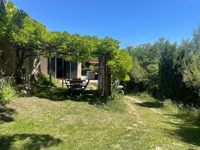 a garden with a table and a fence at La Petite Maison des Baous in Saint-Jeannet