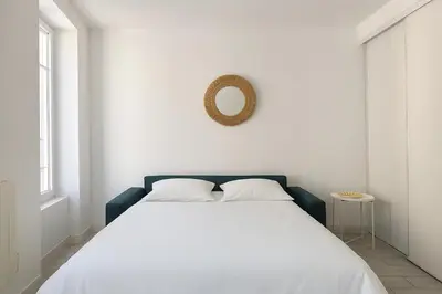 a bedroom with a white bed and a mirror on the wall at Studio Hyper Centre - WIFI - Central in Nice