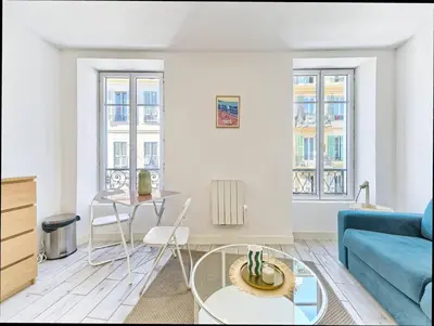 a living room with a blue couch and a table at Studio Hyper Centre - WIFI - Central in Nice