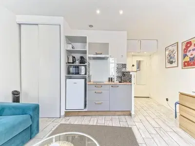 a kitchen with a blue couch in a room at Studio Hyper Centre - WIFI - Central in Nice