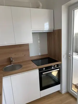 a kitchen with white cabinets and a sink at Vacances à la mer in Cagnes-sur-Mer