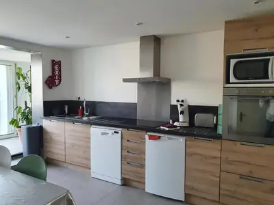 a kitchen with white appliances and wooden cabinets at APPART DANS VILLA AVEC GRANDE TERRASSE PRIVATIVe in Aspremont