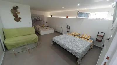 a room with two beds and a couch and a table at APPART DANS VILLA AVEC GRANDE TERRASSE PRIVATIVe in Aspremont