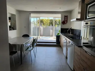 a kitchen with a table with chairs and a dining room at APPART DANS VILLA AVEC GRANDE TERRASSE PRIVATIVe in Aspremont