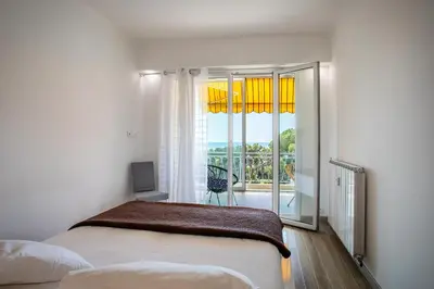 a bedroom with a bed and a window with a view at VISTA MARE AP4459 By Riviera Holiday Home in Villefranche-sur-Mer