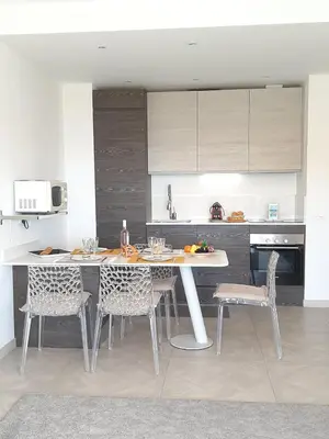 a kitchen with a table and chairs in a kitchen at VISTA MARE AP4459 By Riviera Holiday Home in Villefranche-sur-Mer