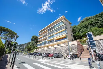 a large building with cars parked in front of a street at VISTA MARE AP4459 By Riviera Holiday Home in Villefranche-sur-Mer
