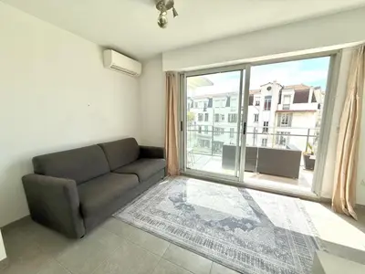 a living room with a couch and a large window at Studio Terrasse 3ème étage, climatisation coeur de Nice in Nice
