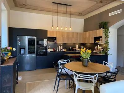 a kitchen with a wooden table and blue cabinets at Chambre Vue Jardin Alsace Lorraine Victor Hugo in Nice