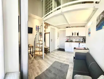 a living room with a couch and a kitchen at Appartement moderne & calme proche mer et centre in Nice