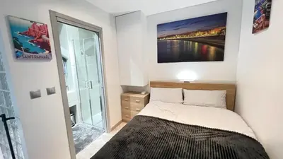 a bedroom with a bed with a picture on the wall at Appartement moderne & calme proche mer et centre in Nice
