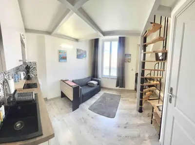 a living room with a couch and a stair case at Appartement moderne & calme proche mer et centre in Nice