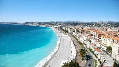 a view of a beach with buildings and the ocean at Appartement moderne & calme proche mer et centre in Nice