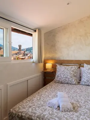 a bedroom with a bed with a window at 12, Boulevard Jean Jaures - Studio in Nice