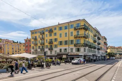 a yellow building on a city street with people walking at 12, Boulevard Jean Jaures - Studio in Nice