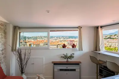 a room with two windows with a view of a city at 12, Boulevard Jean Jaures - Studio in Nice