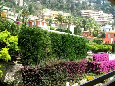 a view of a city with flowers and buildings at La plus belle vue de Villefranche in Villefranche-sur-Mer