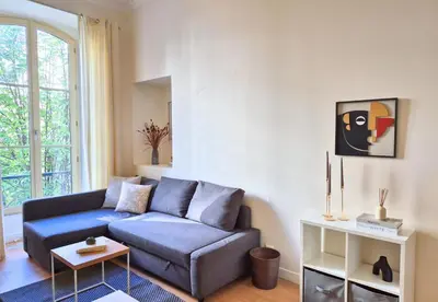 a living room with a blue couch and a window at Nestor&Jeeves - JEAN MEDECIN - Central - Modern in Nice