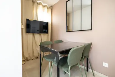 a dining room with a table and chairs and a mirror at Le Neoroch in Nice