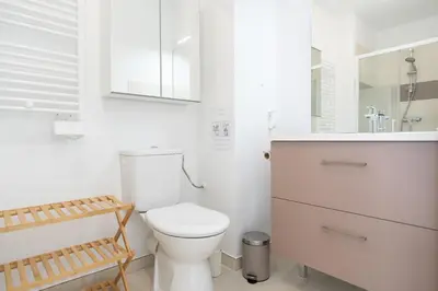 a white bathroom with a toilet and a sink at Le Neoroch in Nice