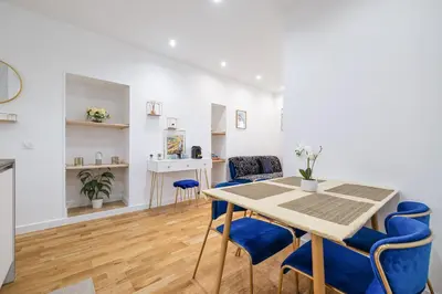 a dining room with a table and blue chairs at Nice Renting - 5 Massena - Elegant Air-Conditioned Cocoon Quiet Patio Massena in Nice