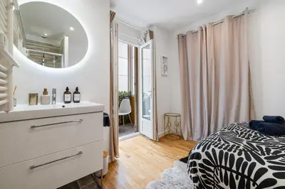 a bedroom with a bed and a sink and a mirror at Nice Renting - 5 Massena - Elegant Air-Conditioned Cocoon Quiet Patio Massena in Nice