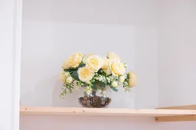 a vase filled with yellow roses on a shelf at Nice Renting - 5 Massena - Elegant Air-Conditioned Cocoon Quiet Patio Massena in Nice