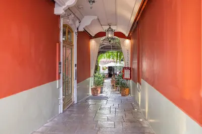 an alleyway with orange walls and potted plants at Nice Renting - 5 Massena - Elegant Air-Conditioned Cocoon Quiet Patio Massena in Nice
