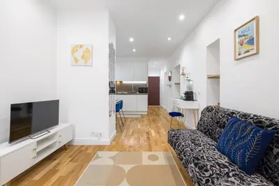 a living room with a couch and a flat screen tv at Nice Renting - 5 Massena - Elegant Air-Conditioned Cocoon Quiet Patio Massena in Nice